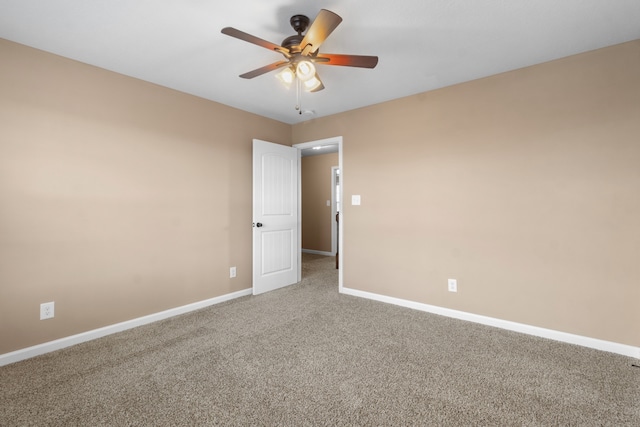 carpeted spare room featuring ceiling fan