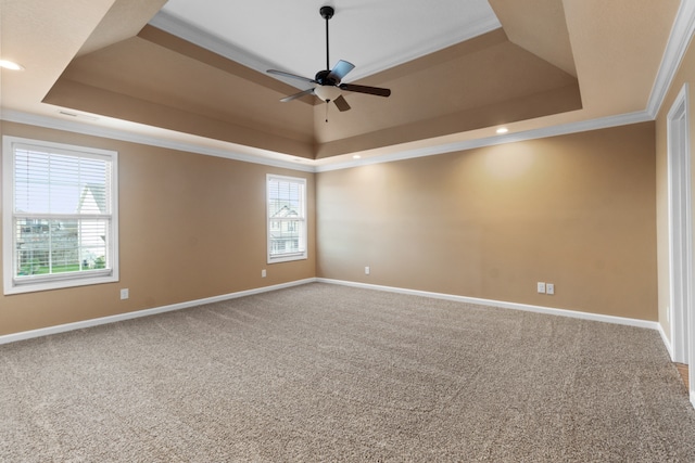 unfurnished room with a raised ceiling, plenty of natural light, and ornamental molding