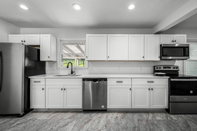 kitchen with stainless steel appliances, sink, and white cabinets