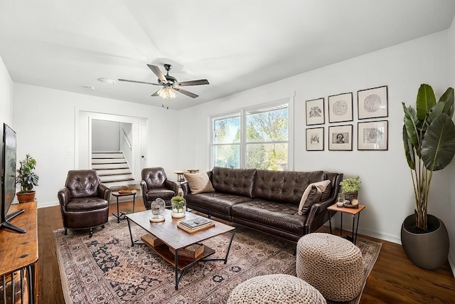 living room featuring dark wood-type flooring and ceiling fan