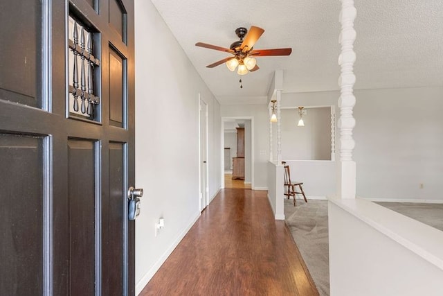 entrance foyer featuring ceiling fan, dark hardwood / wood-style flooring, and a textured ceiling