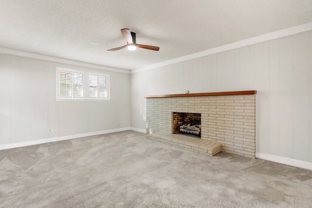 unfurnished living room with carpet flooring, ceiling fan, crown molding, a textured ceiling, and a fireplace