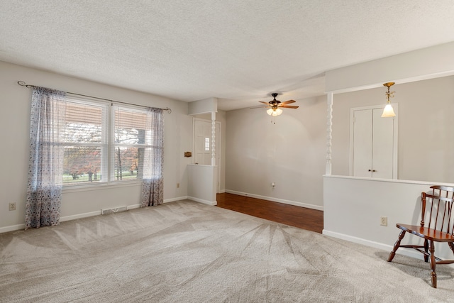 interior space with light carpet, a textured ceiling, and ceiling fan