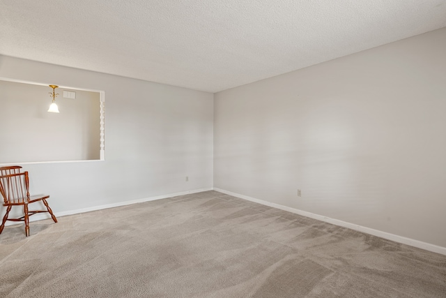 carpeted spare room featuring a textured ceiling