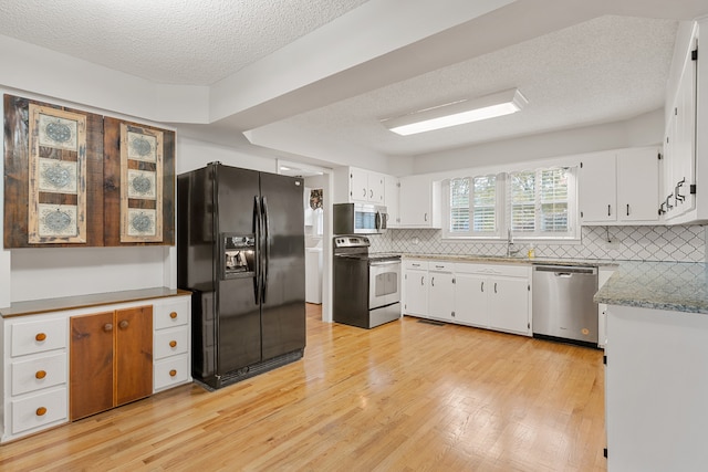 kitchen with white cabinets, sink, light hardwood / wood-style flooring, a textured ceiling, and stainless steel appliances