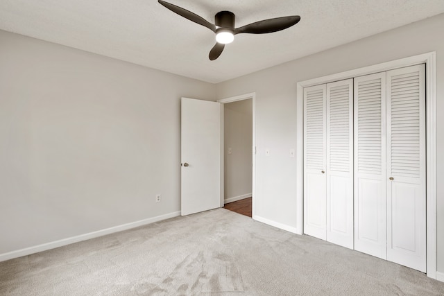 unfurnished bedroom with carpet flooring, ceiling fan, and a closet