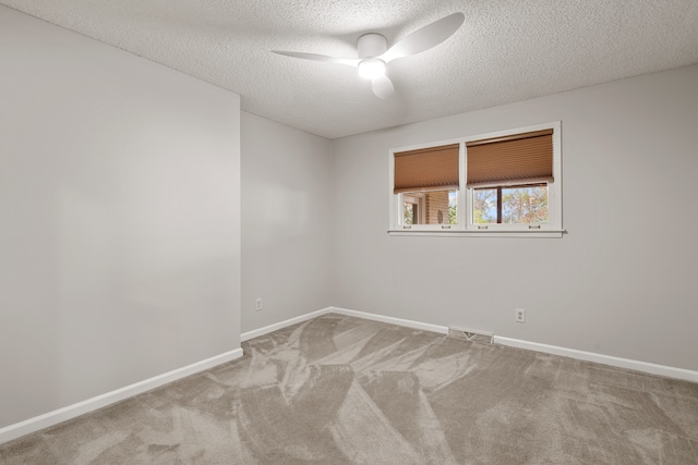 carpeted spare room featuring a textured ceiling and ceiling fan