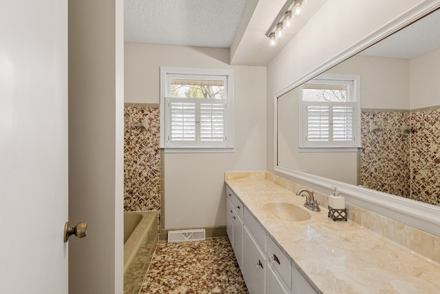 bathroom featuring tile patterned floors, vanity, shower / bath combination, and a textured ceiling