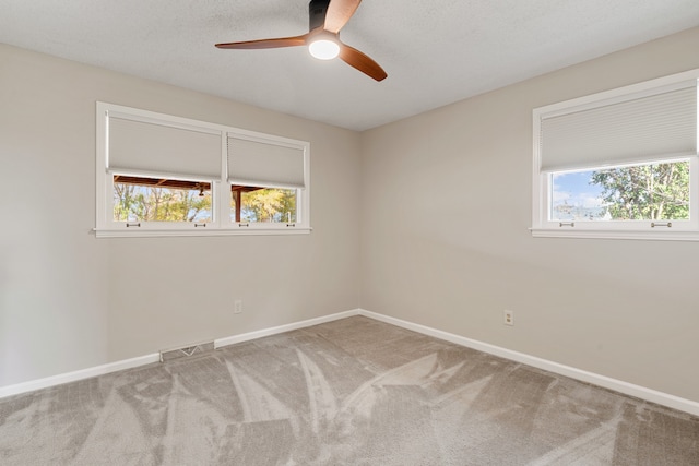 carpeted spare room featuring ceiling fan and a textured ceiling