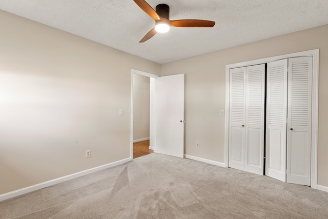 unfurnished bedroom featuring a textured ceiling, carpet floors, a closet, and ceiling fan