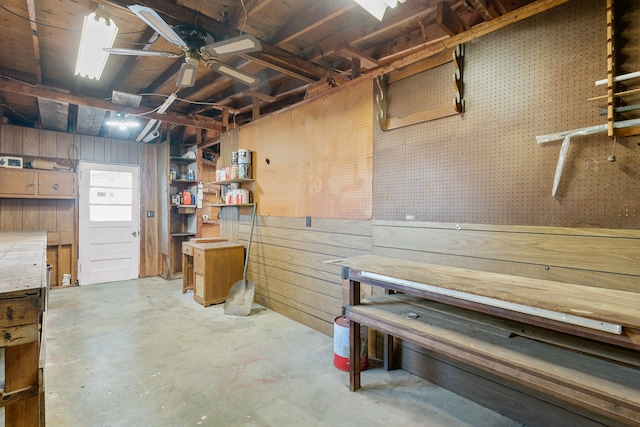 basement with a workshop area and wood walls