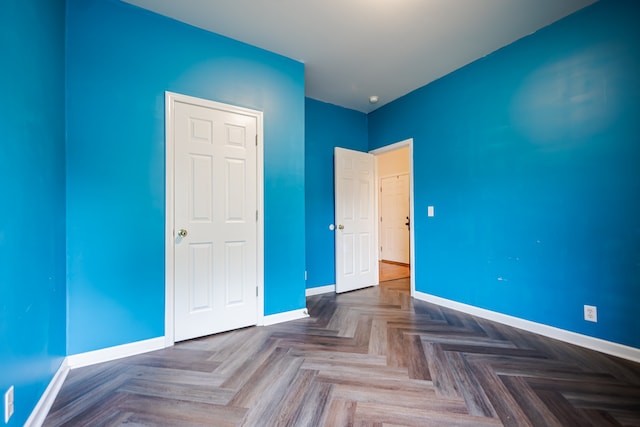 unfurnished bedroom featuring parquet floors