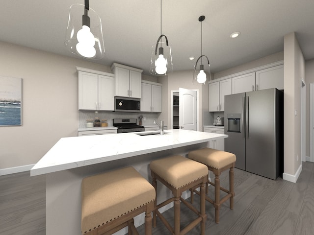 kitchen featuring decorative light fixtures, sink, appliances with stainless steel finishes, and an island with sink