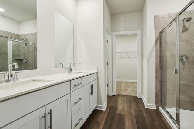 bathroom featuring hardwood / wood-style floors, vanity, and a shower with door