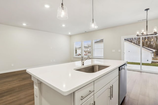 kitchen featuring a center island with sink, sink, white cabinetry, dishwasher, and hanging light fixtures