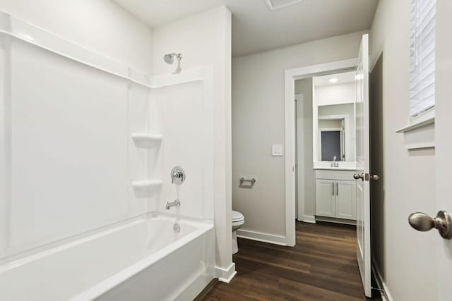 full bathroom with toilet, hardwood / wood-style flooring, vanity, and tub / shower combination