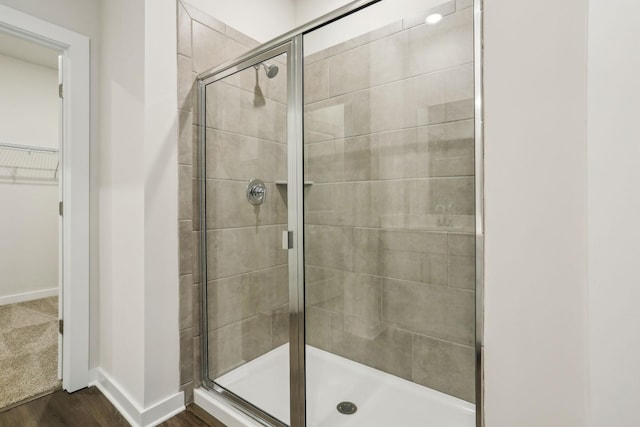 bathroom featuring hardwood / wood-style flooring and a shower with shower door