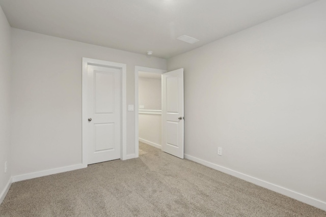 unfurnished bedroom featuring light carpet