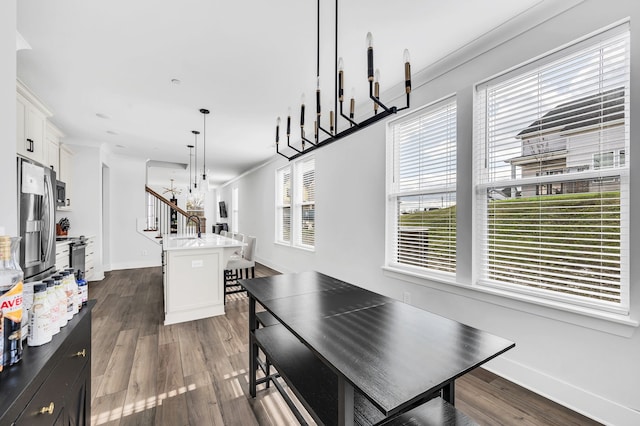 dining area with a wealth of natural light, dark hardwood / wood-style flooring, and ornamental molding