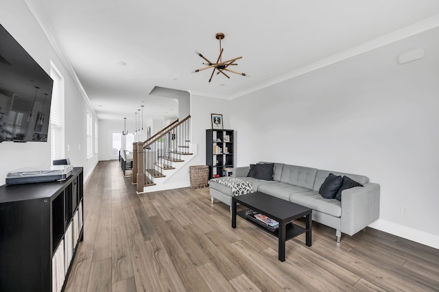 living room featuring hardwood / wood-style flooring, an inviting chandelier, and ornamental molding