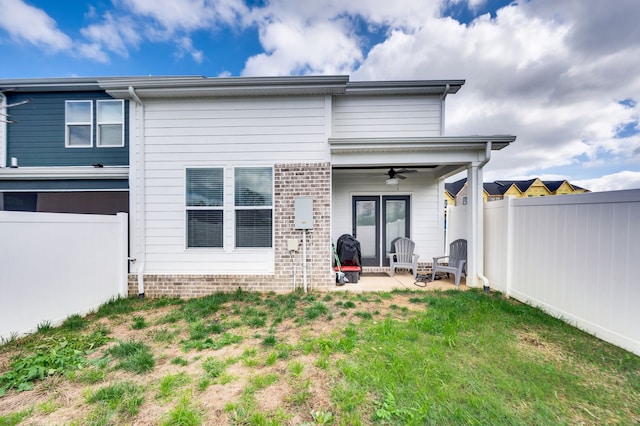 back of property featuring a lawn, ceiling fan, a patio, and french doors