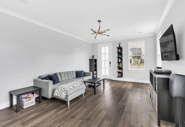 living room featuring dark hardwood / wood-style floors, crown molding, and a chandelier