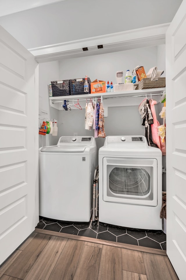 clothes washing area with separate washer and dryer and dark wood-type flooring