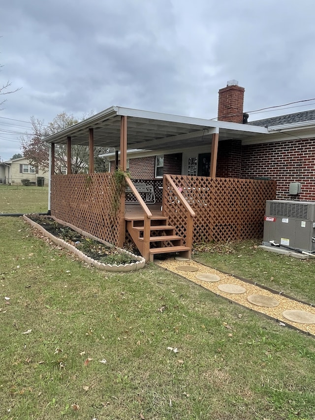 rear view of property with a yard, central AC unit, and a deck