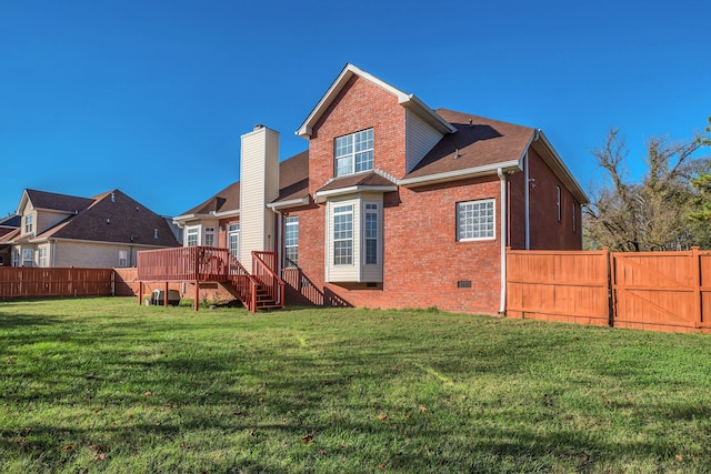 rear view of house with a yard and a wooden deck