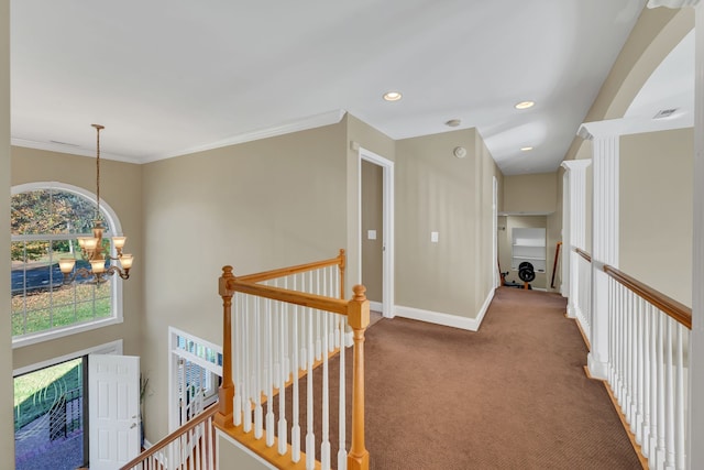 hall featuring carpet floors, ornamental molding, and an inviting chandelier