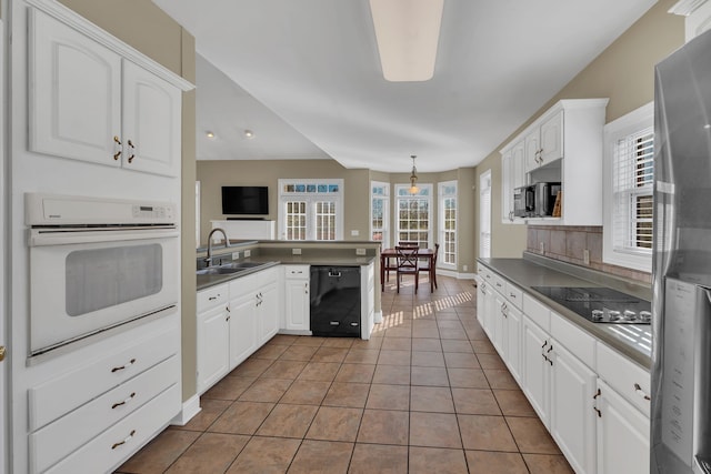 kitchen featuring kitchen peninsula, sink, white cabinets, and black appliances