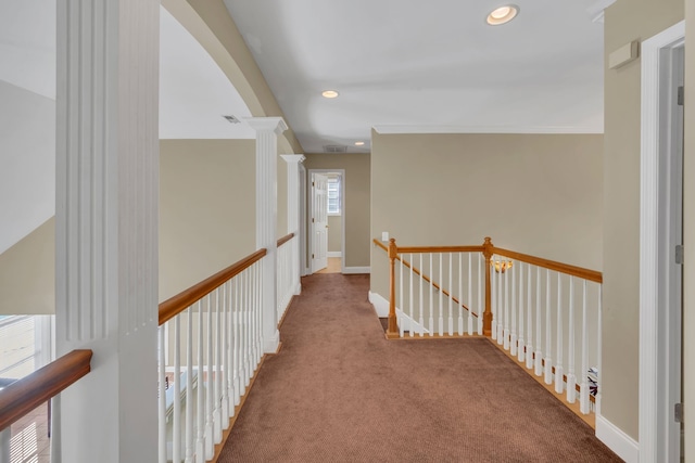 hallway with carpet, ornate columns, and crown molding