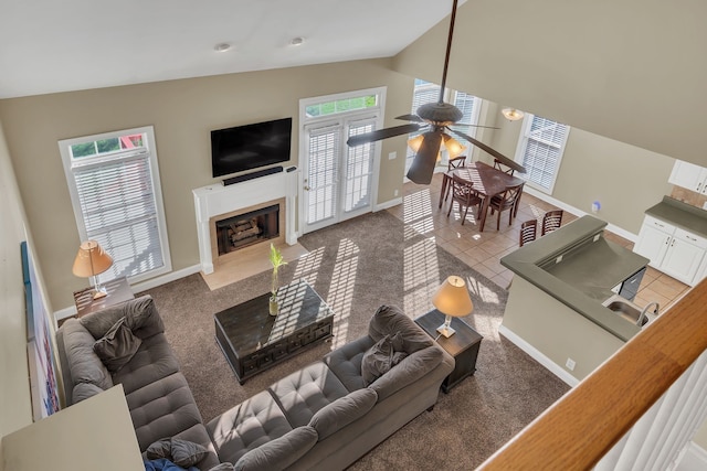 living room featuring tile patterned floors, plenty of natural light, ceiling fan, and vaulted ceiling