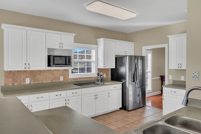 kitchen featuring decorative backsplash, appliances with stainless steel finishes, white cabinetry, and sink