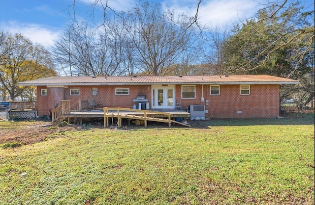 back of property featuring crawl space, french doors, brick siding, and a yard