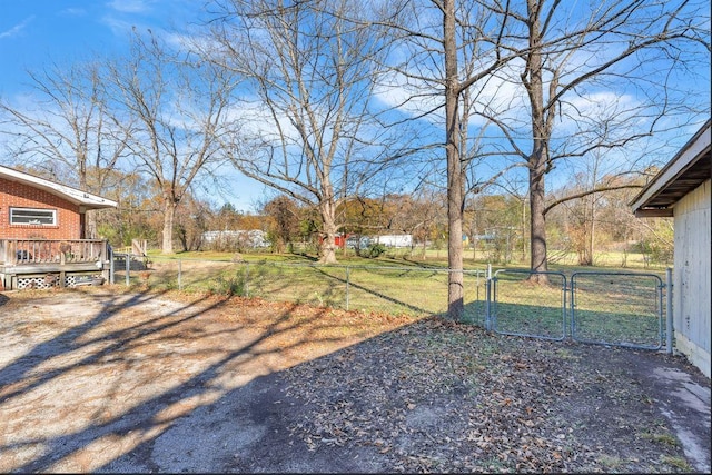 view of yard featuring fence, a deck, and a gate