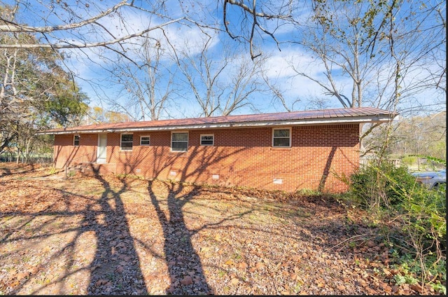 view of side of property with brick siding and crawl space