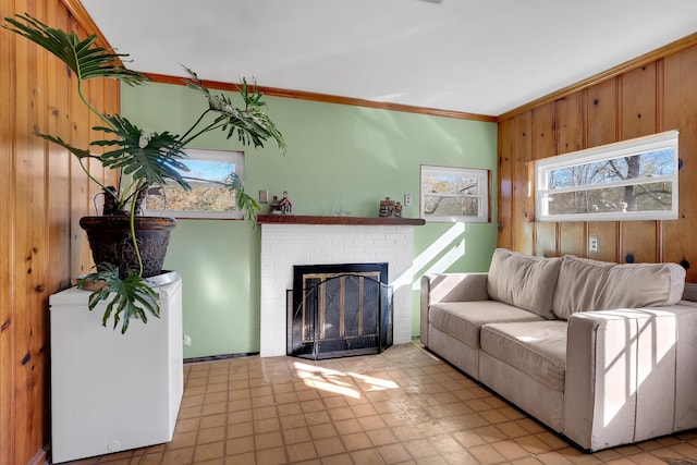 living room featuring a healthy amount of sunlight, ornamental molding, a fireplace, and wood walls