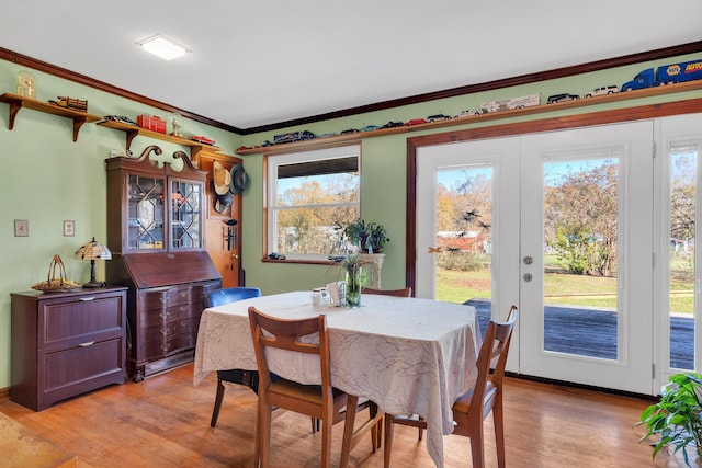 dining room featuring light wood-style floors, french doors, and ornamental molding