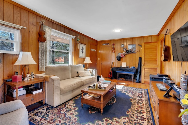 living room with wood walls, crown molding, and wood finished floors