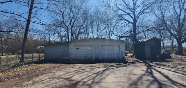 detached garage featuring fence