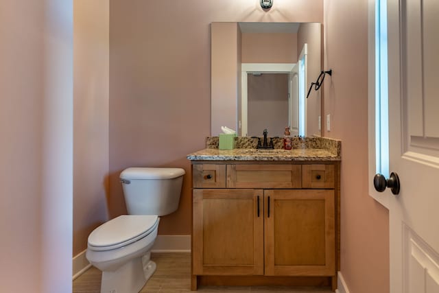 bathroom with hardwood / wood-style flooring, vanity, and toilet