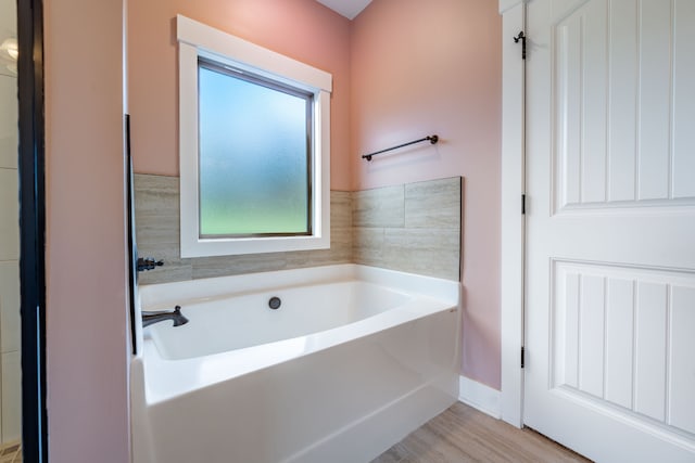 bathroom featuring wood-type flooring and a tub