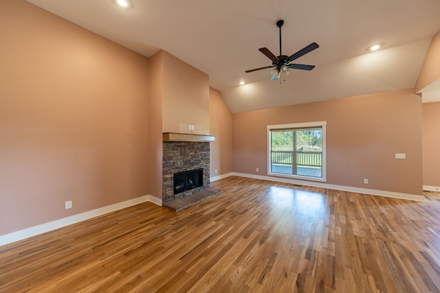 unfurnished living room featuring light wood-type flooring, high vaulted ceiling, a stone fireplace, and ceiling fan