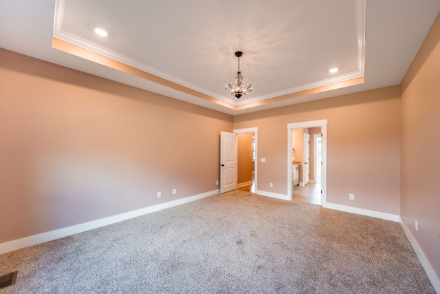 unfurnished room featuring a chandelier, a raised ceiling, and crown molding