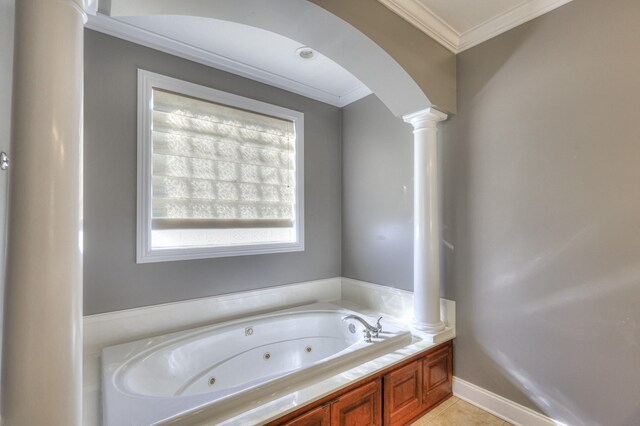 bathroom with decorative columns, a tub, tile patterned flooring, and ornamental molding