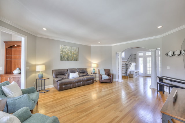 living room with decorative columns, light hardwood / wood-style flooring, and crown molding