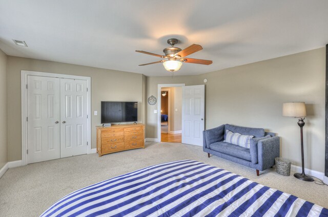 bedroom with light colored carpet, a closet, and ceiling fan