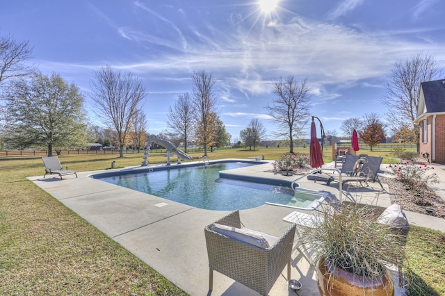 view of swimming pool featuring a patio area, a yard, and a water slide