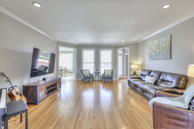 living room featuring plenty of natural light, light hardwood / wood-style floors, and ornamental molding